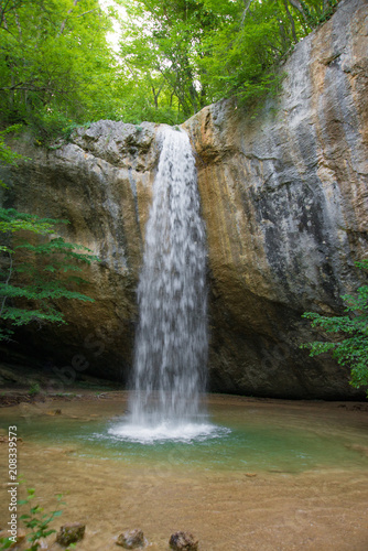 Mountain waterfall vertical in the spring forest