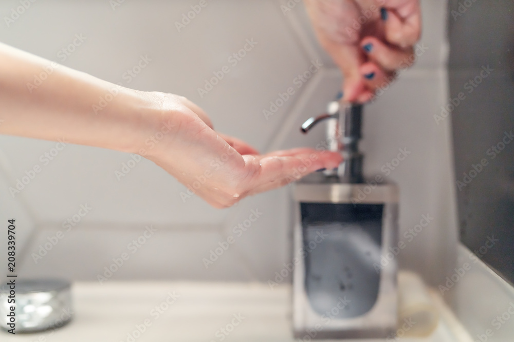 women washing hand with liquid soap in restroom women washing hand with liquid soap in restroom