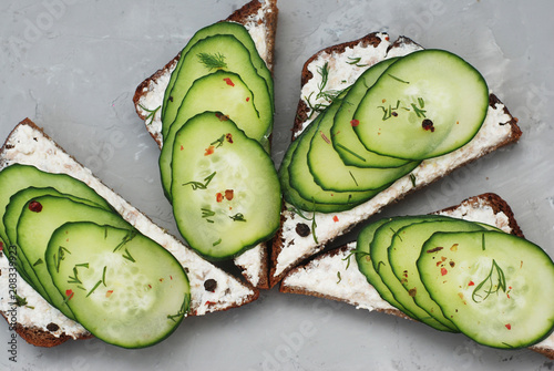 Fresh Vegan Sandwitches with Cucumber and Cheesecream over Gray Textured Background photo