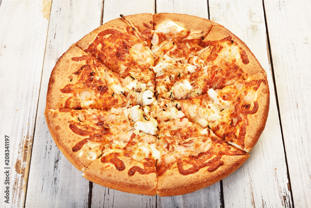 Delicious fresh pizza with seafood on wooden table. Delicious fresh pizza with seafood on wooden table.
