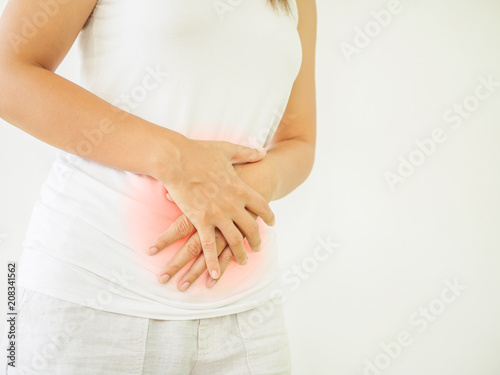 Woman having a stomachache, or menstruation pain with white background. Health care and medical concept.