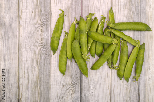 Green pea pods on a wooden background