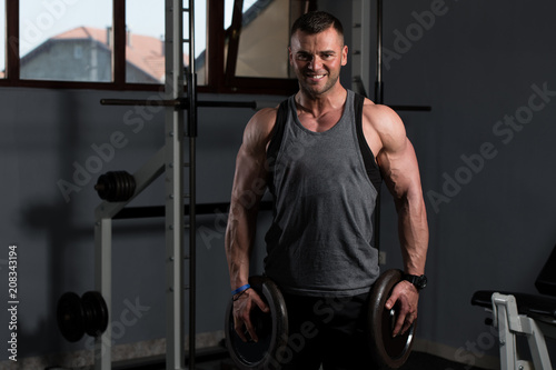 Fit Man Holding Weights In Hand © Jale Ibrak