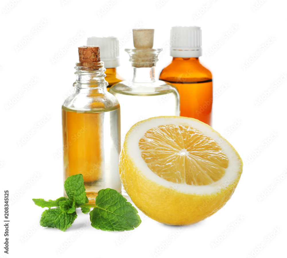 Bottles of citrus essential oil and lemon on white background Bottles of citrus essential oil and lemon on white background