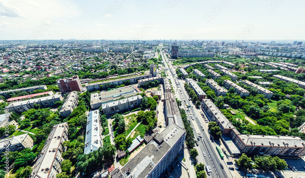 Aerial city view with crossroads and roads, houses, buildings, parks and parking lots, bridges. Helicopter drone shot. Wide Panoramic image.