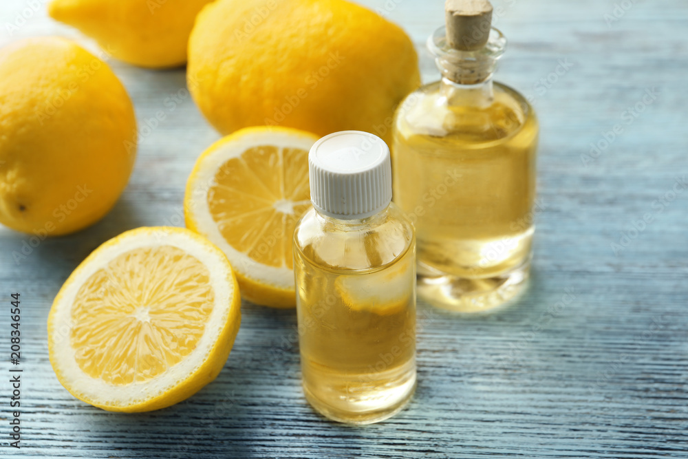 Bottles with citrus essential oil and sliced fruit on wooden table Bottles with citrus essential oil and sliced fruit on wooden table