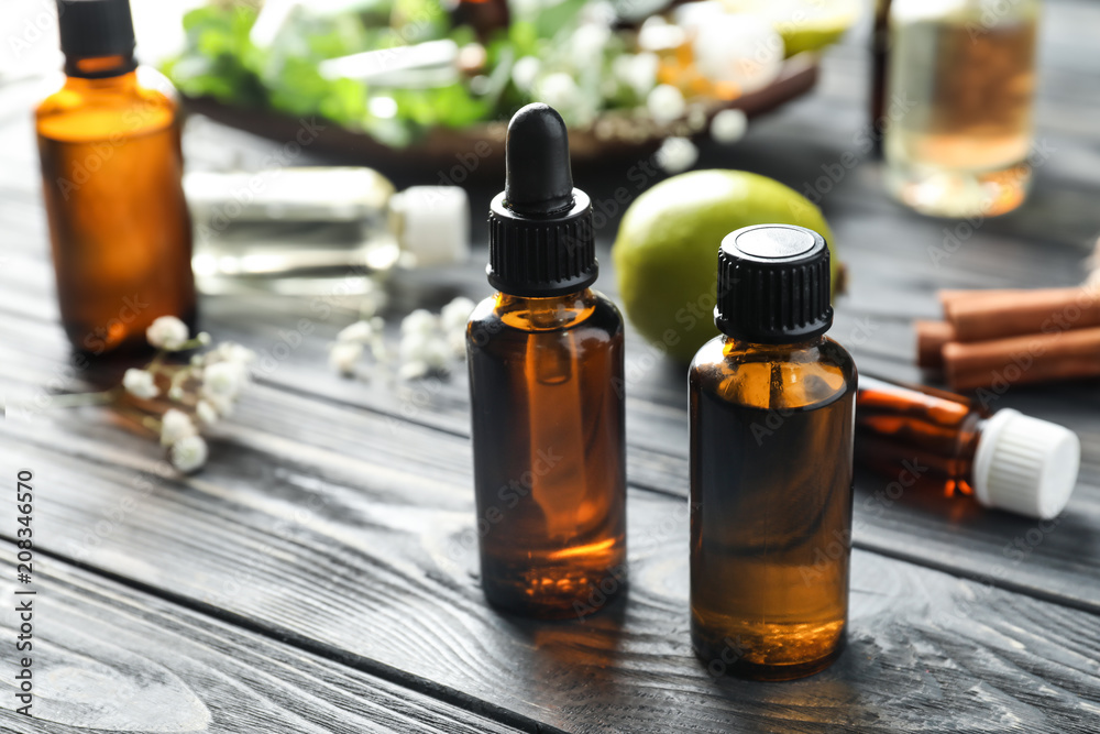 Bottles with citrus essential oil on wooden table Bottles with citrus essential oil on wooden table