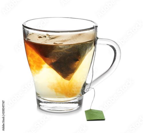 Brewing of hot tea in glass cup on white background