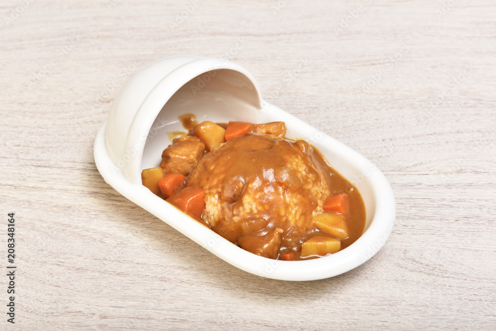 Curry with rice on a plate of shape of toilet Curry with rice on a plate of shape of toilet