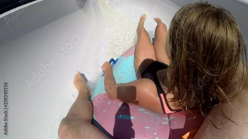 Father and daughter having fun on a waterslide