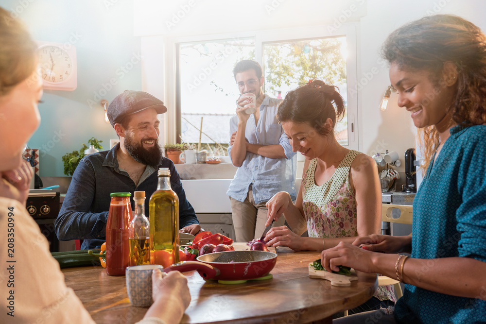 Multi-ethnic group of friends cooking lunch in the kitchen. Multi-ethnic group of friends cooking lunch in the kitchen.