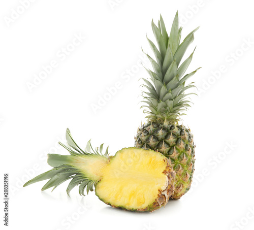 Half of fresh ripe pineapple and whole fruit on white background
