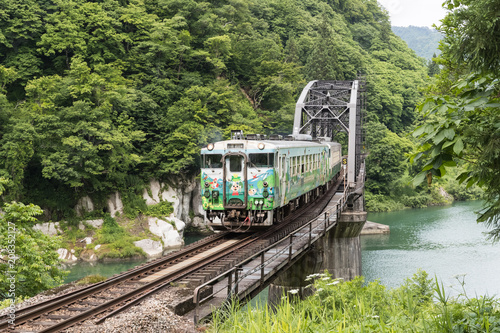 FUKUSHIMA, JAPAN - June 18 : The local train Tadami line and Tadami river on June 18 , 2017 in Fukushima , Japan. This train services in East Japan railway company's Tadami line.