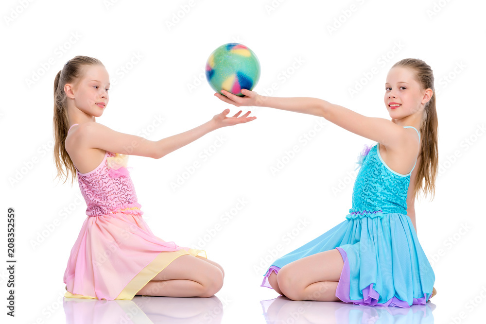 Girls gymnasts perform exercises with the ball. Girls gymnasts perform exercises with the ball.
