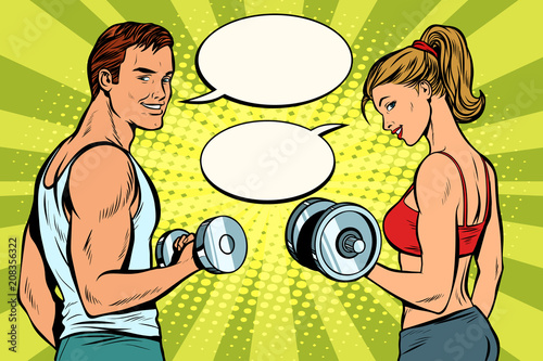 Man and woman in the gym with dumbbells