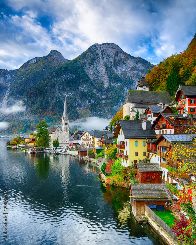 Naklejka premium Mglisty jesienny wschód słońca w słynnym mieście nad jeziorem Hallstatt, odzwierciedlając w jeziorze Hallstattersee