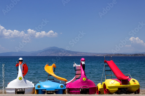 Bright pedal boat  with slides are waiting for tourists near the sea. Concept-  tourism, vacation by the sea. photo