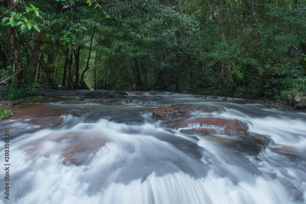 Fototapeta premium waterfalls in deep forest at National Park ,A beautiful stream water famous rain forest waterfall in Thailand