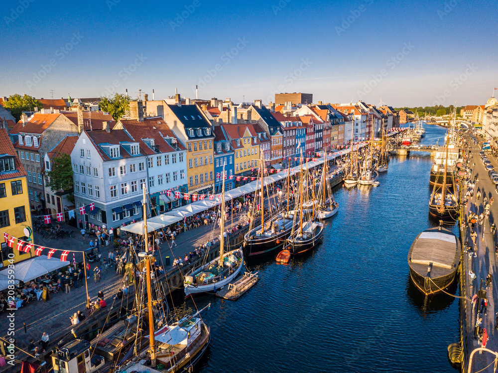 Amazing historical city center. Nyhavn New Harbour canal and entertainment district in Copenhagen, Denmark. The canal harbours many historical wooden ships. Aerial view from the top.