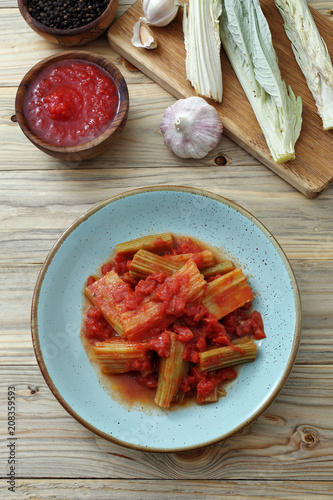 cardoni in salsa di pomodoro su tavolo di cucina photo