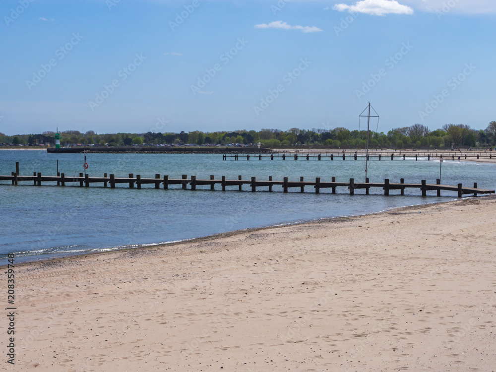 beach on the baltic sea with a view of two wooden bridges