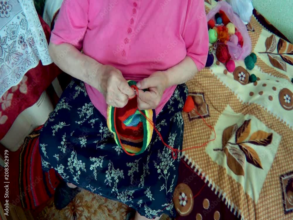 elderly woman knits a product elderly woman knits a product