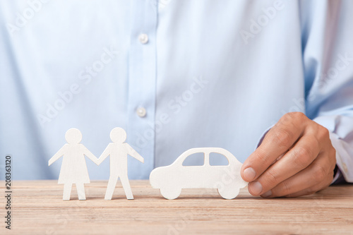 The concept of car rental, credit or insurance. Man in shirt is holding car in his hand and next to his family