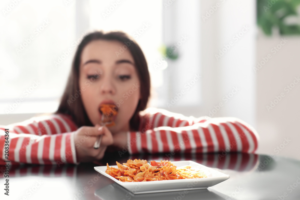 Young woman eating delicious pasta at table, closeup Young woman eating delicious pasta at table, closeup