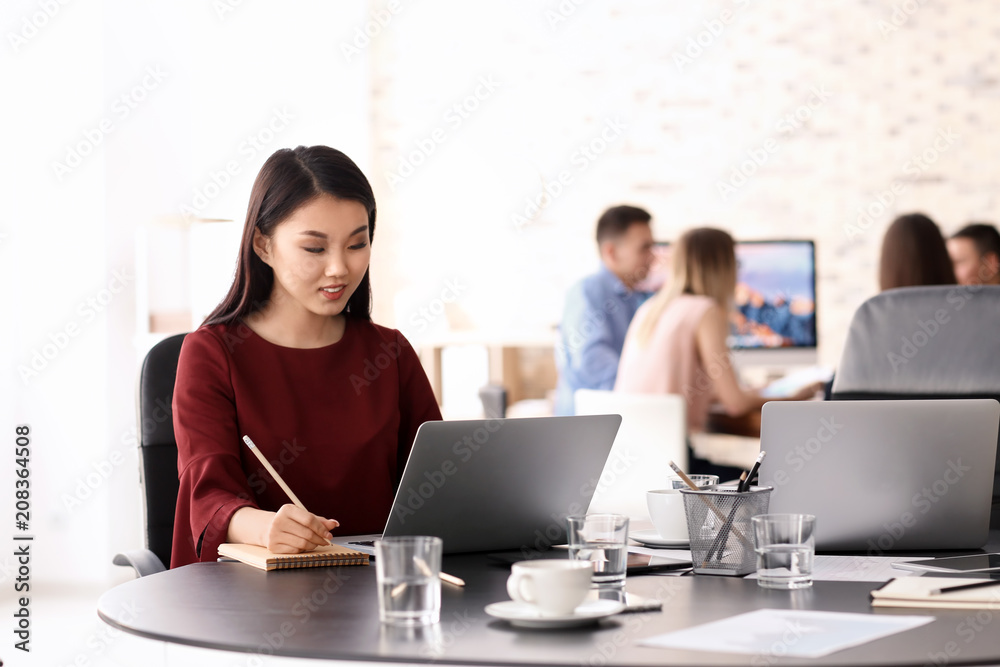 Young woman using laptop to get ready for business meeting in office Young woman using laptop to get ready for business meeting in office