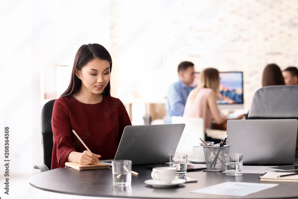 Young woman using laptop to get ready for business meeting in office