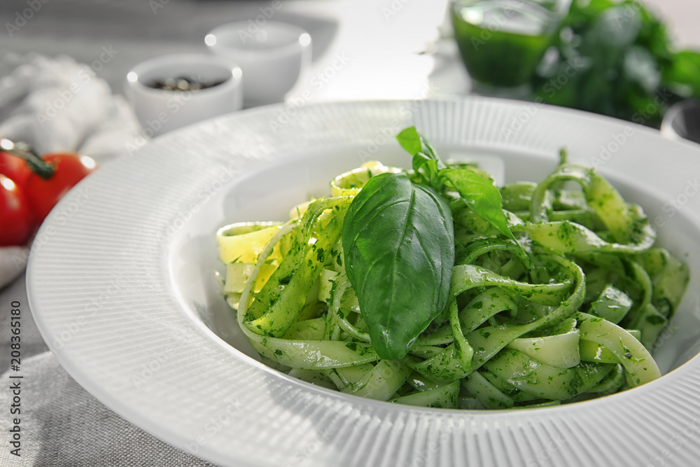 Plate of delicious pasta with pesto sauce on table, closeup Plate of delicious pasta with pesto sauce on table, closeup
