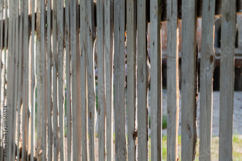 Wooden peeled fence, wooden background on a sunny day.