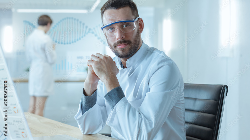 Fototapeta premium In the Futuristic Laboratory Male Scientists Looking into Camera. He is Working on the Transparent Display Computer. Screen Shows Interactive DNA Visualisation and Futuristic User Interface.