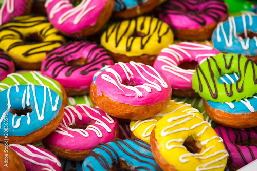 Many colorful donuts  background of different color cakes
