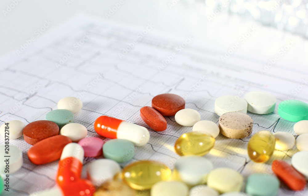 Colored pills poured from a brown bottle. Medical concept