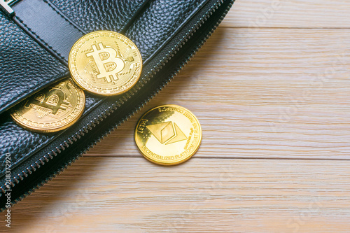 Crypto currency. Coins Bitcoin (BTC), banknotes one hundred dollars sticking out of a man's black leather purse on a wooden background.Blockchain.Intarnational currency.Top view.E-commerce.E-business. photo