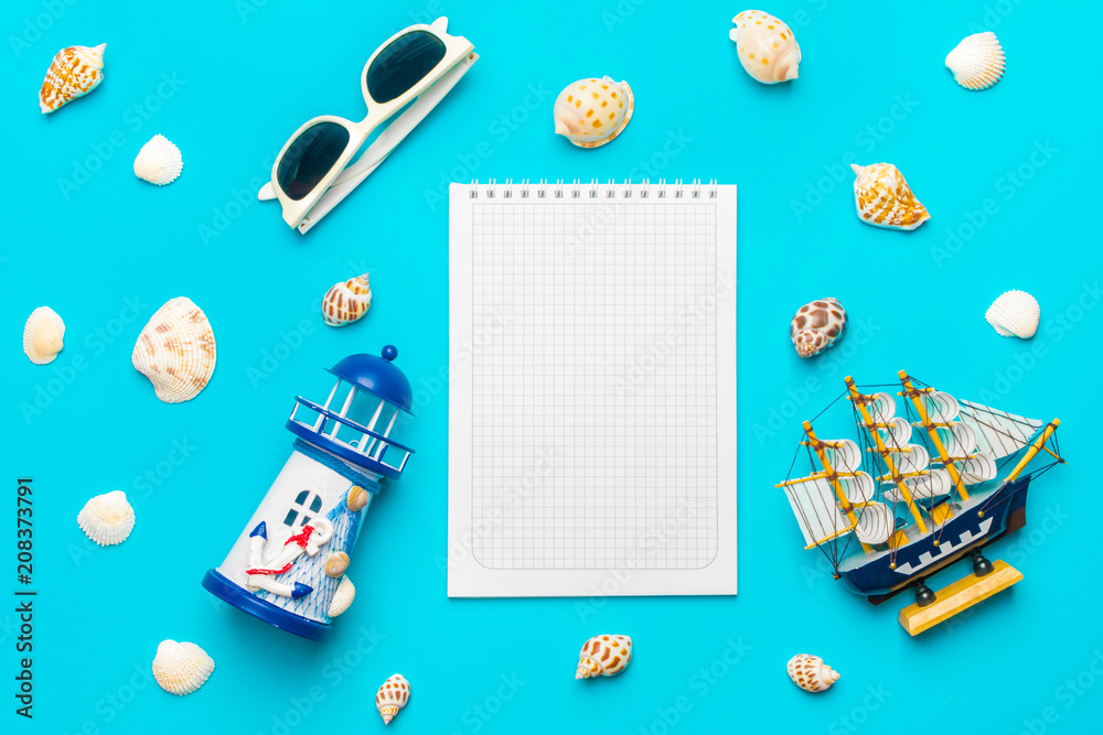 Flat lay traveler accessories -lighthouse, ship,  shell, glasses on the blue background with blank space for text. Top view travel or vacation concept. Summer background.Mock up.Copy space
