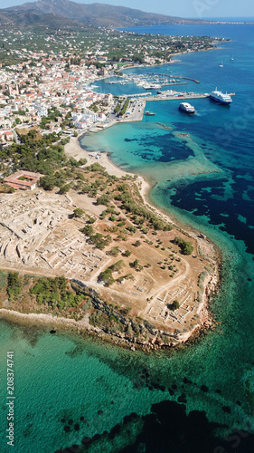 Aerial drone bird's eye view of iconic temple of Apollo on top of Kolona hill with only one pillar left standing, Aigina island, Saronic gulf, Greece