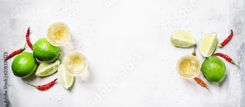 Fototapeta Naklejka Na Ścianę i Meble -  Gold mexican tequila with lime and salt, white drink background, top view