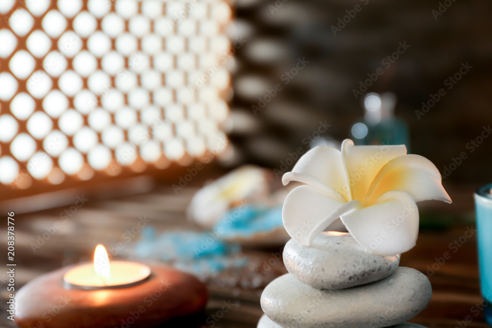 Spa stones with beautiful flower on table