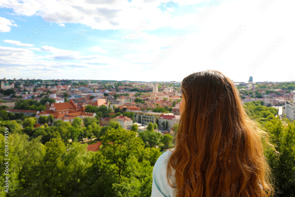 Young tourist woman looking to Vilnius city from panoramic point of view, Lithuania, Baltic States, Europe