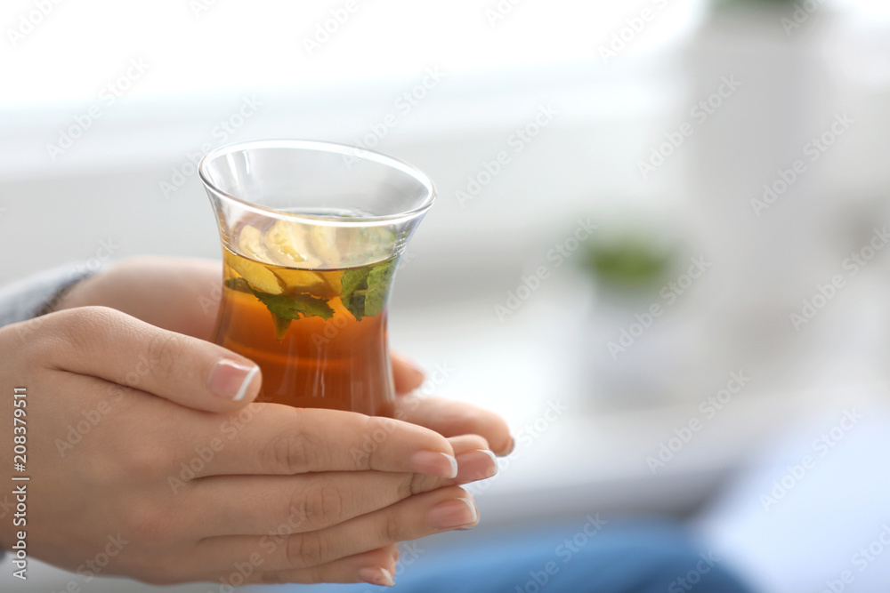 Young woman with cup of hot tea at home, closeup Young woman with cup of hot tea at home, closeup