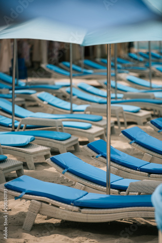 empty chaise lounges and umbrellas at beach