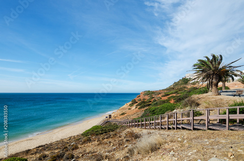 Wooden stairway leading to the beautiful sandy beach of Salema village. Sagres (Vila do Bispo), District Faro, Algarve, Southern Portugal.