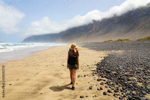 Tableau sur toile Girl is watching the suggestive landscape of Caleta Famara, Lanzarote, Canary Is