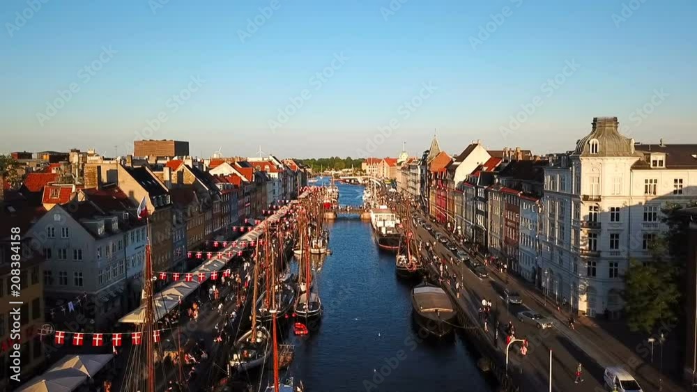 amazing busy old street in Copenhagen, Denmark. bridge in Nyhavn New Harbour canal and entertainment district. Aerial Video footage view from the top. forward movement. Sunset golden time light
