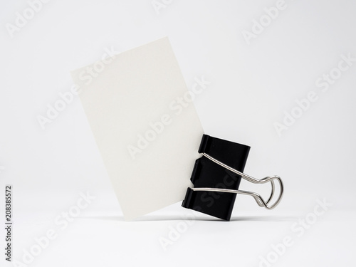 White blank business card being held by a black binder clip, isolated, mock up