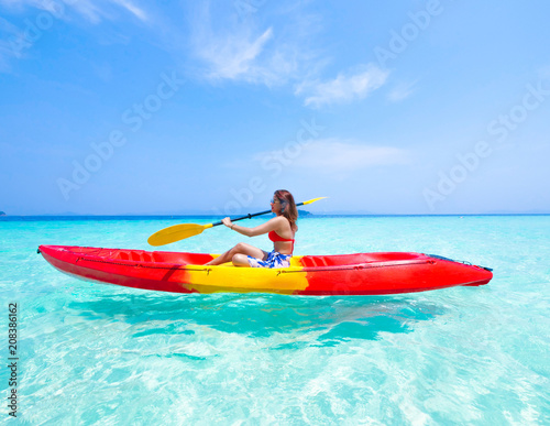 Asian woman on the kayak boat in Andaman blue sea and blue sky background location in Phuket island Thailand © chayathon2000