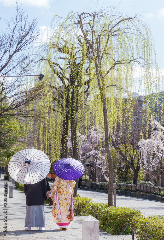 Obraz premium Młoda para ubrana w kimono z parasolami w Kyoto, Japonia