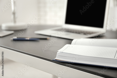 Comfortable workplace with notebook on table